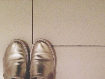 Close-up of shoes on tiled floor