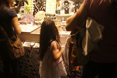 Rear view of girl and woman at market stall