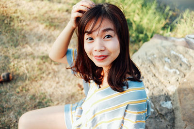 Portrait of young woman sitting on field