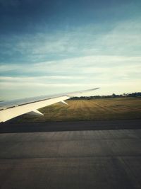 Airplane on runway against sky