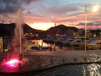 Boats in harbor at sunset