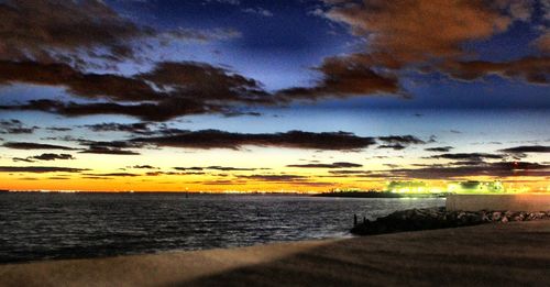 Scenic view of sea against dramatic sky during sunset