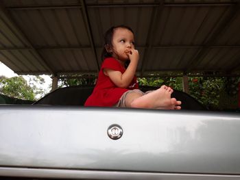 Cute girl looking away while sitting in car