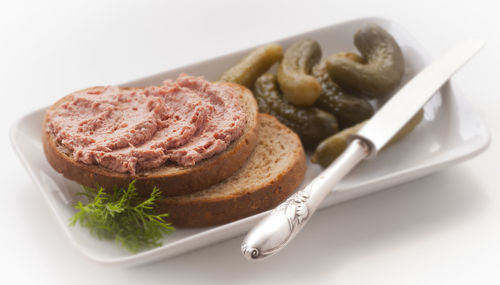 Close-up of breakfast served in plate over white background