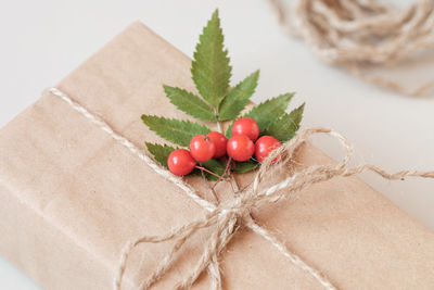 A christmas gift wrapped in kraft paper and decorated with a bunch of mountain ash. close-up