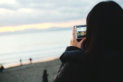 Rear view of silhouette man looking at sunset