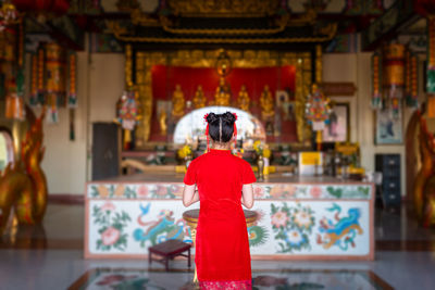 Rear view of woman standing in temple