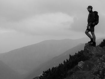 Man standing on mountain against sky