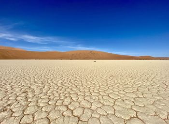 Scenic view of desert against blue sky