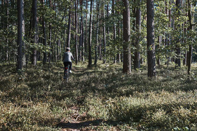 Active woman cycling on forest road. female riding bicycle off-road route on summer vacation day