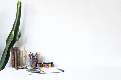 Close-up of colored pencils on table against white background