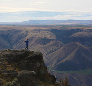 Rear view of man on mountain against sky