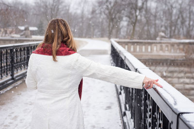 Rear view of woman on snow covered car