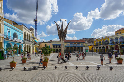 People on street against buildings in city