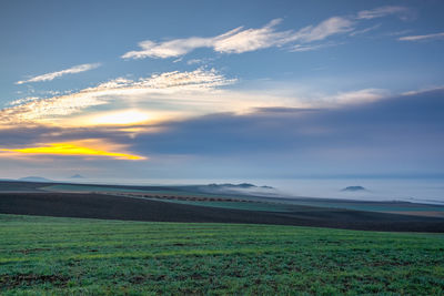 Scenic view of field against sky during sunset