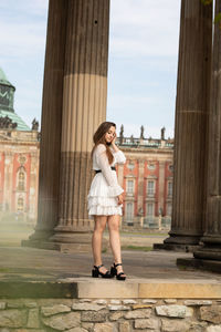Full length of woman standing against built structure