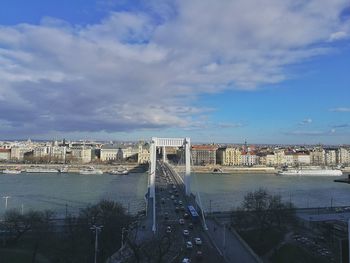 City at waterfront against cloudy sky