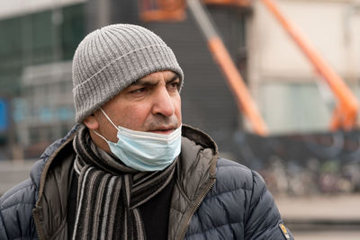 Man with protective mask, lowered to the chin. incorrect wearing of medical masks under quarantine