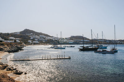 Sailboats moored in sea against clear sky