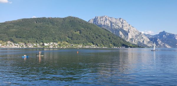 Scenic view of sea and mountains against clear sky