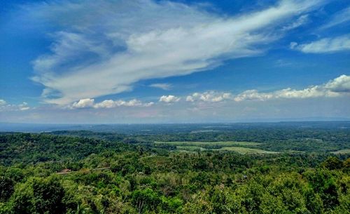 Scenic view of green landscape against cloudy sky