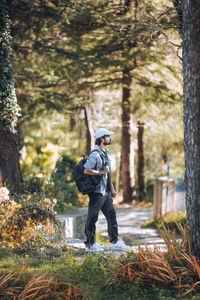 Rear view of man standing in forest with a backpack