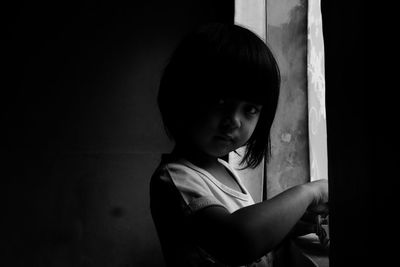 Side view of young woman looking through window