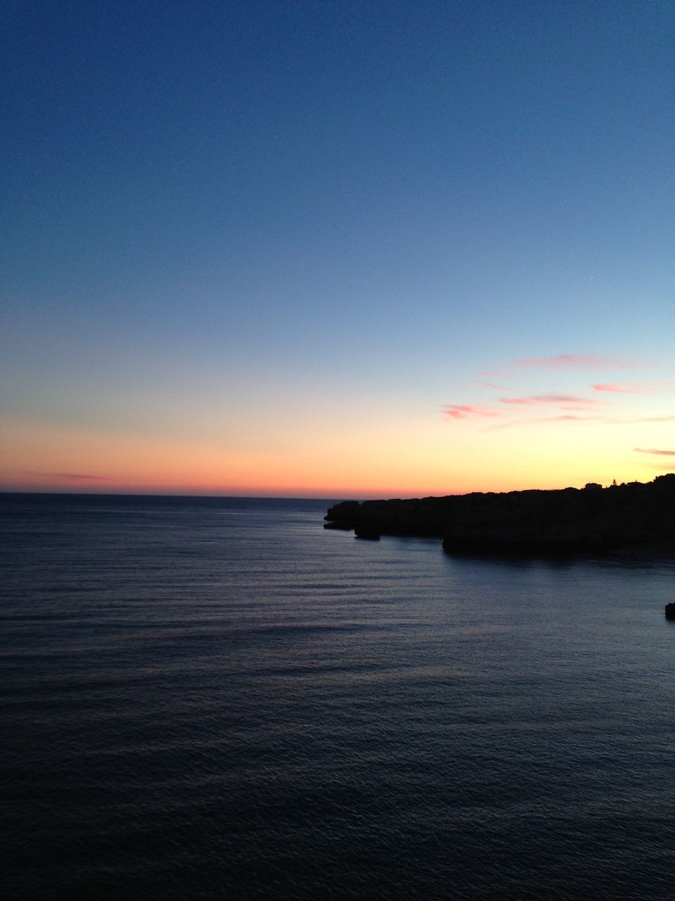 VIEW OF CALM SEA AT SUNSET