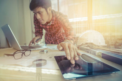 Man using mobile phone while standing on table