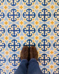 Low section of person standing on tiled floor