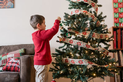 Young boy decorating a christmas tree