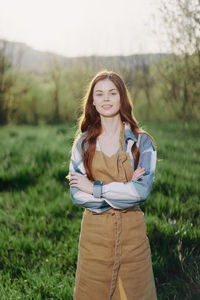 Portrait of young woman standing on field