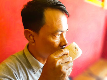 Close-up portrait of a man holding drink