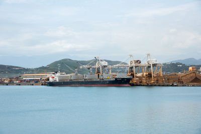 Commercial dock by sea against sky