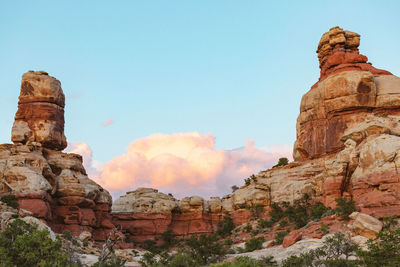 Blue skies and pink clouds over red sandstone towers in canyonlands