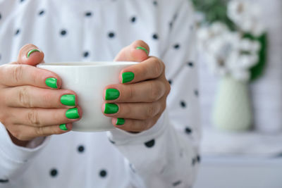 Close-up of hand holding coffee cup