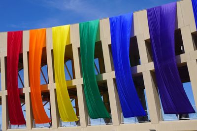 Multi colored textiles on building against sky