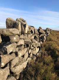 Stack of rocks on field against sky