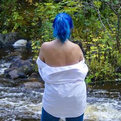 Rear view of woman standing in forest