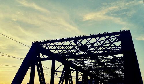 Low angle view of silhouette bridge against sky