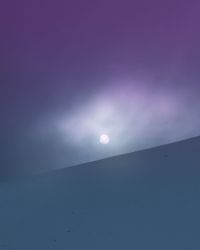 Low angle view of moon against blue sky at night