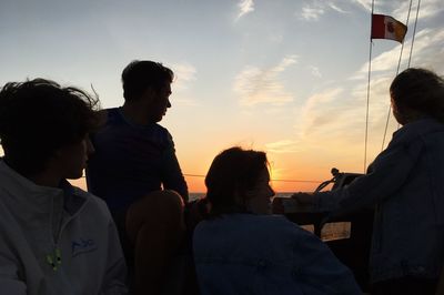 People standing against sky during sunset