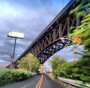 Road by bridge against sky