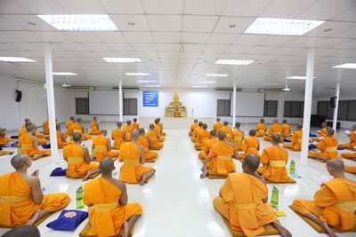 Monks praying while sitting in room 