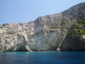 Scenic view of sea and mountains against clear sky