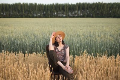 Young woman wearing a hat surrounded by a natural scene 