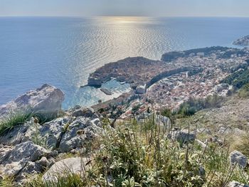 High angle view of townscape by sea against sky