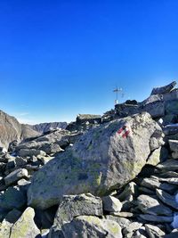 Rocks on mountain against clear blue sky