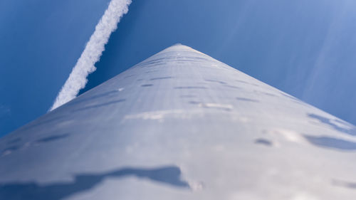Low angle view of airplane wing against blue sky