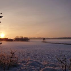 Scenic view of frozen lake against sky during sunset